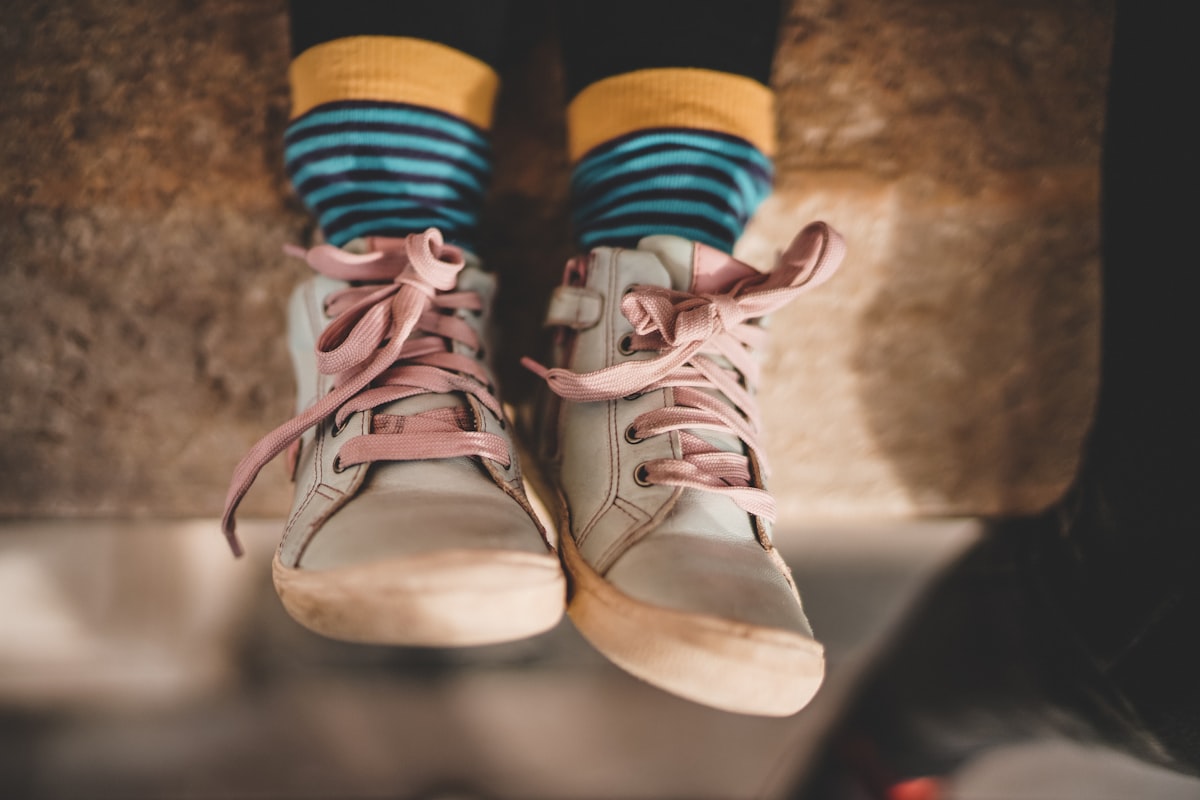 A pair of small beige rubber shoes on a light background