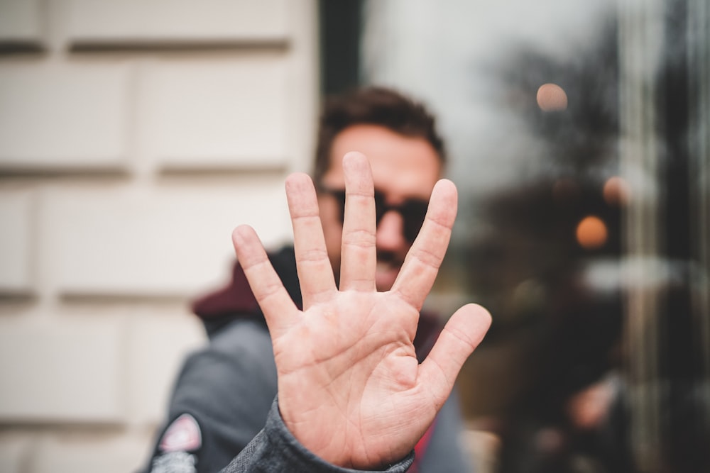 uomo che alza la mano destra