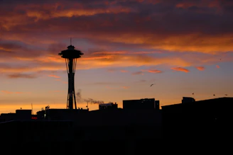 A sleek website footer featuring a stylized silhouette of a famous landmark at sunset.