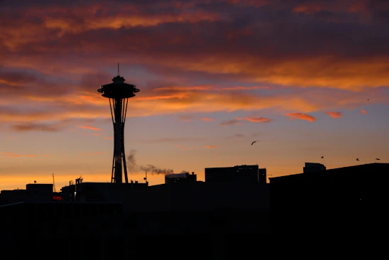 A sleek website footer featuring a stylized silhouette of a famous landmark at sunset.