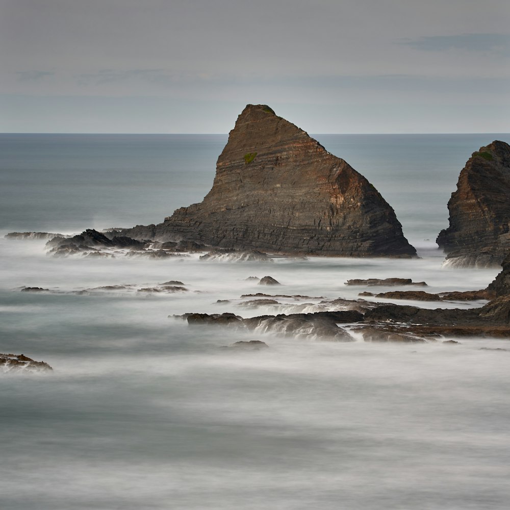 water splashing on brown rock