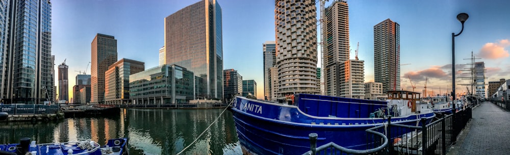 panoramic photography of blue boat docked near sidewalk