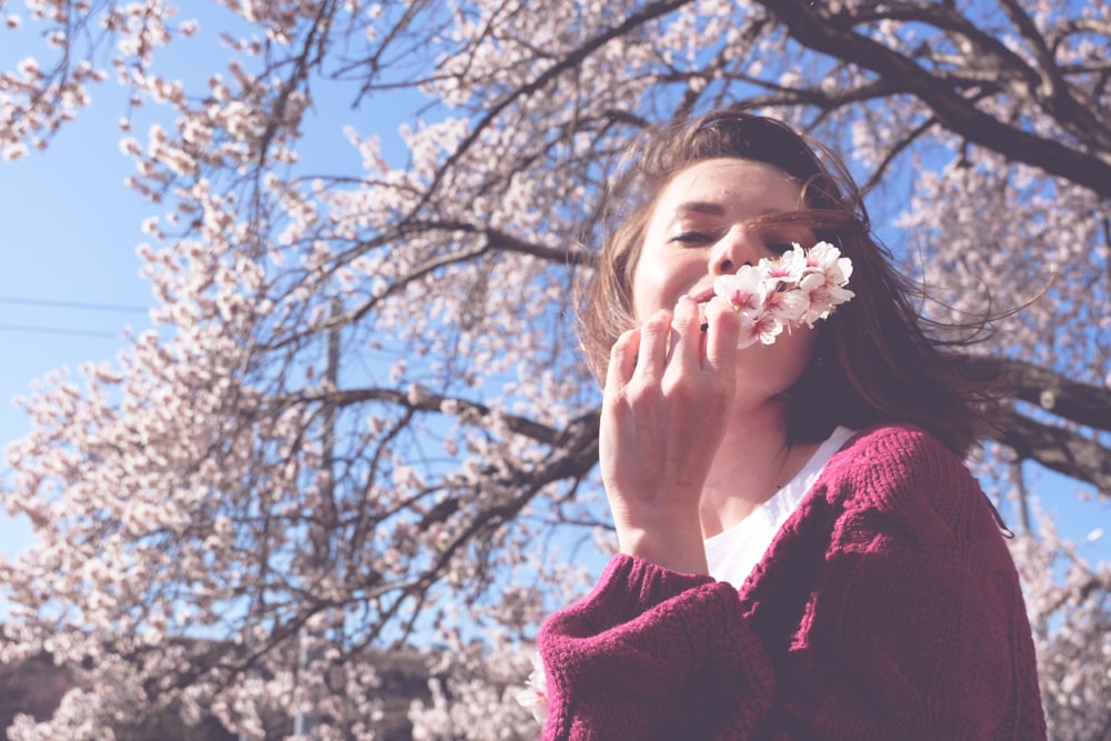 woman holding pink-petaled flower