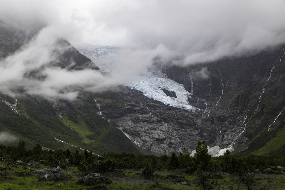 grass field mountains during cloud formation