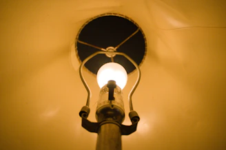 Close-up of a marble table lamp with a glowing Edison bulb, highlighting its elegant details.