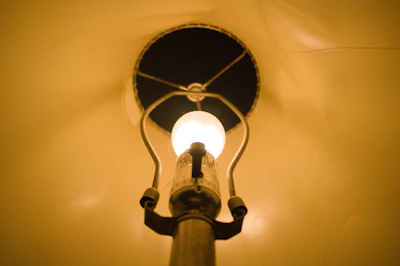 Close-up of a marble table lamp with a glowing Edison bulb, highlighting its elegant details.