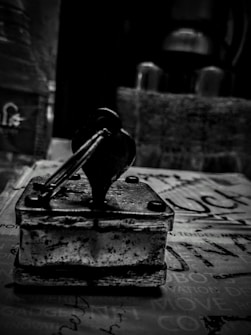 Close-up of a classic wooden-handled rubber stamp pressing onto ink pad.