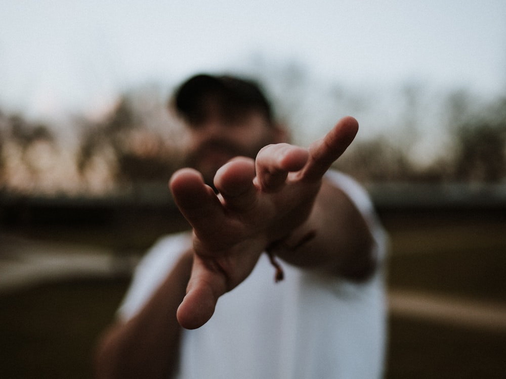 selective focus photography of man pointing his hand