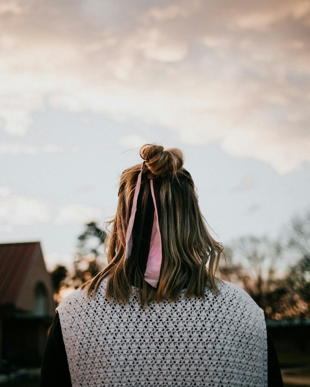 woman wearing white knitted vest photo across clouds