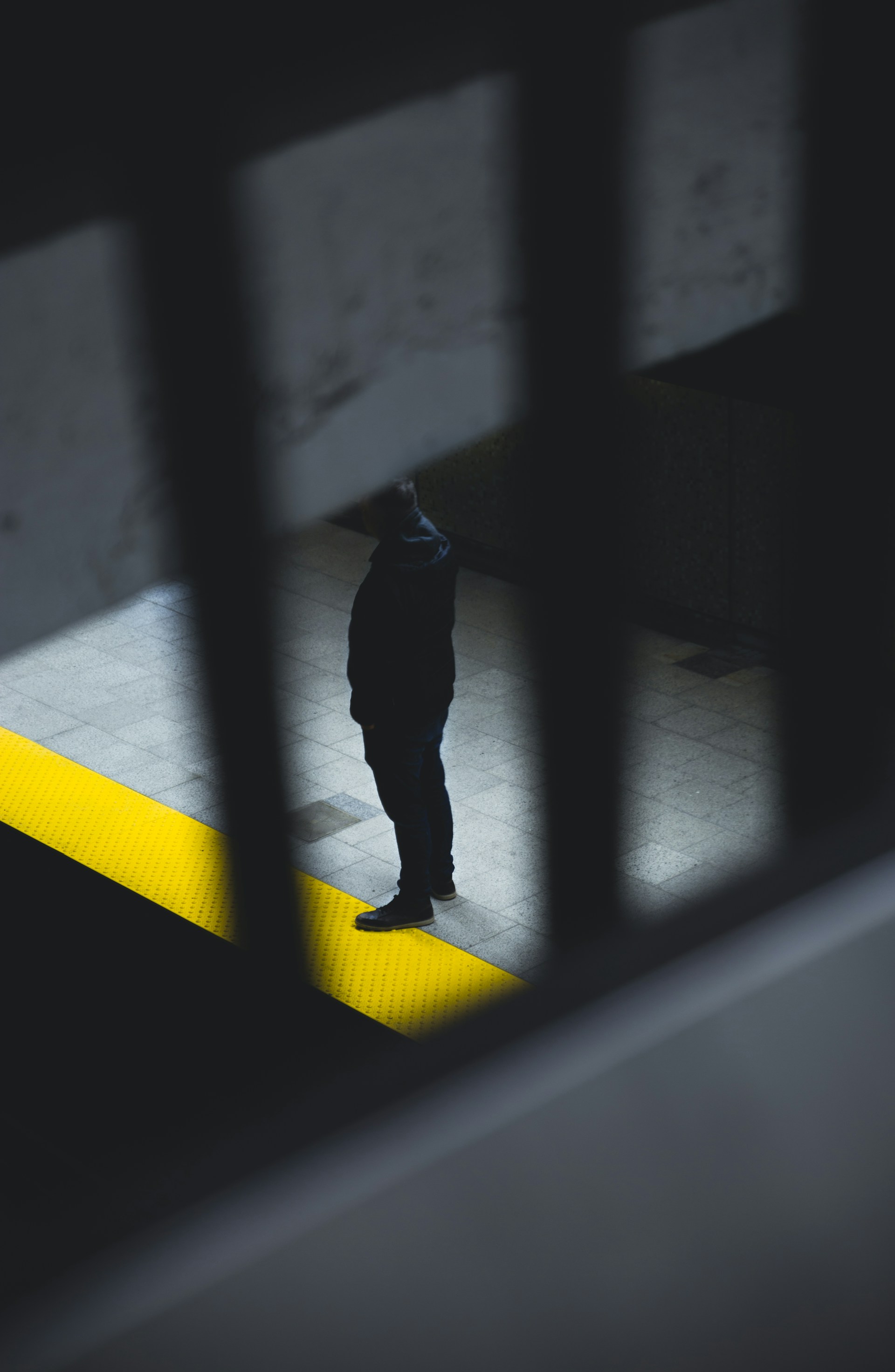 a man standing on a subway platform with his back to the camera