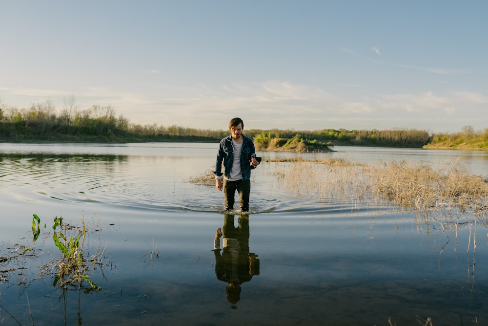 man standing in body of water during daytime