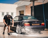 man washing BMW coupe