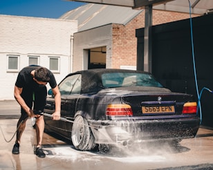 man washing BMW coupe