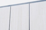Exterior house facade with a smooth, even coat of light gray paint.