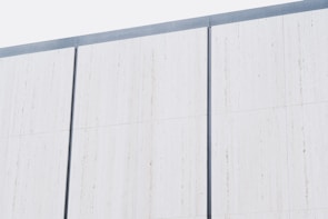 Wide shot of a residential exterior wall featuring custom aluminium paneling with clean lines.