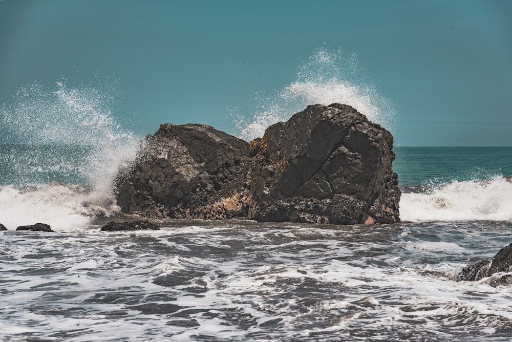 shallow focus photo of gray stone formation on ocean