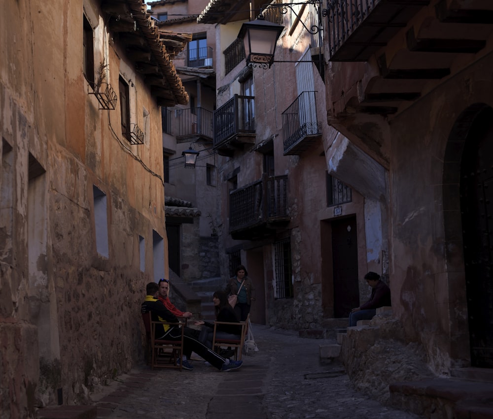 two men sitting on bench beside wall