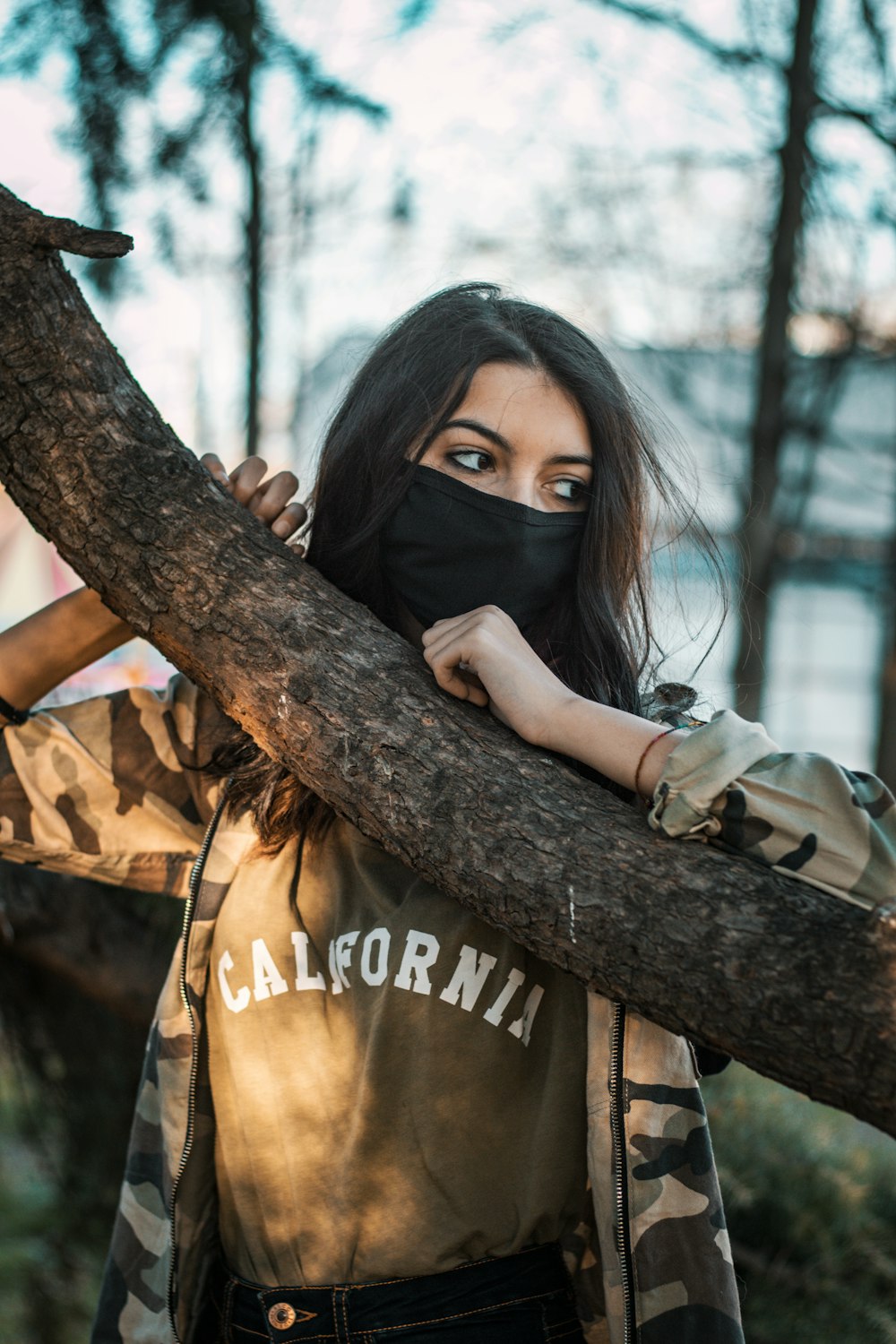 selective focus photo of woman leaning on the branch of tree