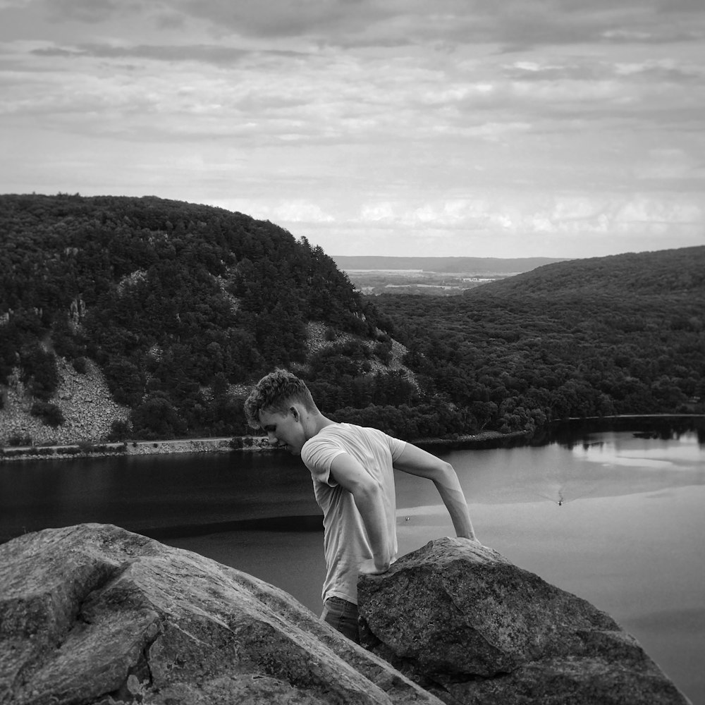 man leaning on boulder