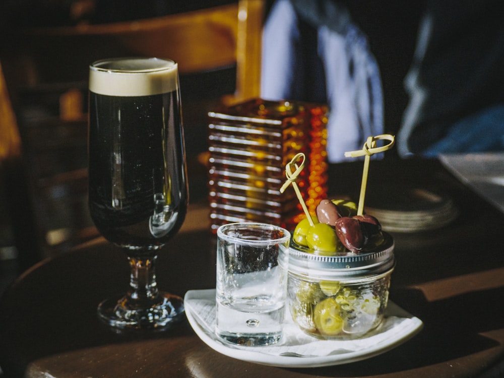 clear shot glass beside liquid filled footed glass