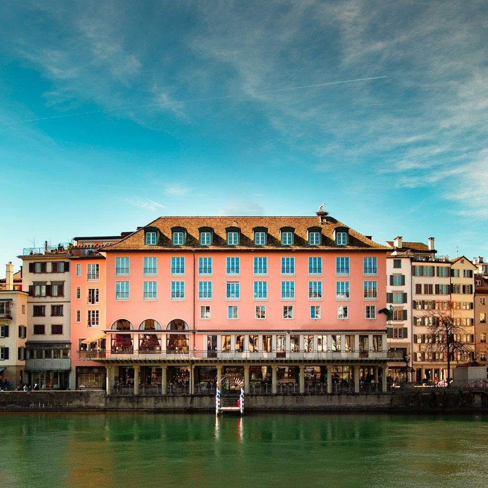 struttura dell'edificio rosa e marrone vicino allo specchio d'acqua