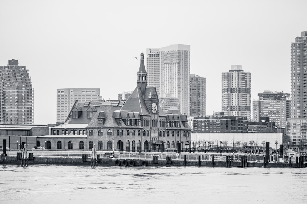 panoramic grayscale photo of building facing body of water