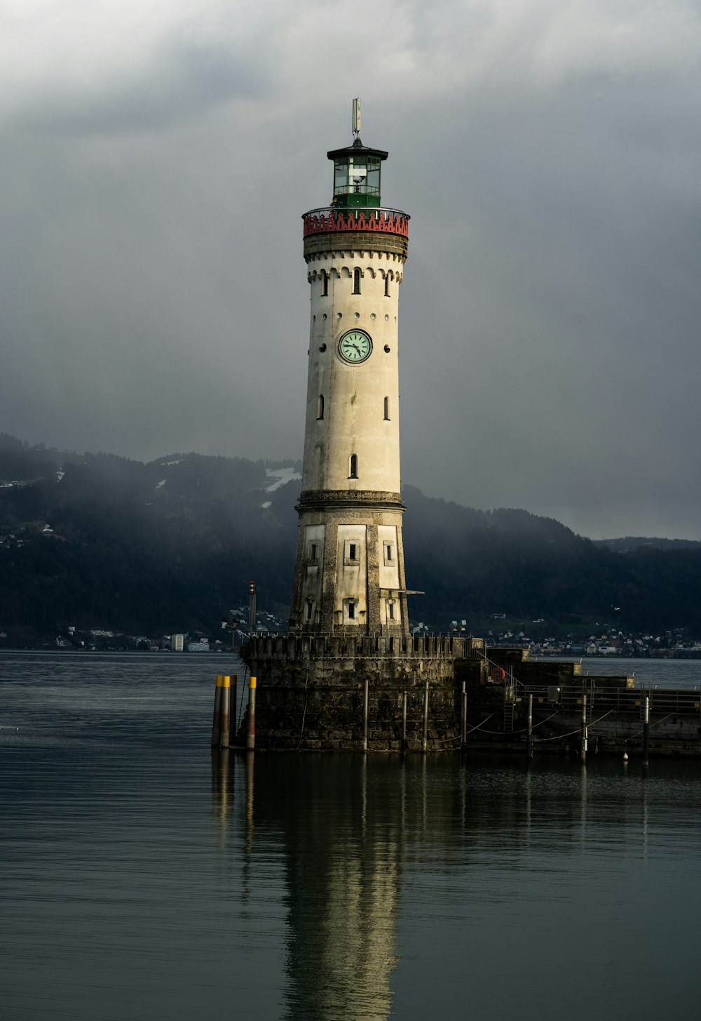 farol branco perto de corpo de água calma