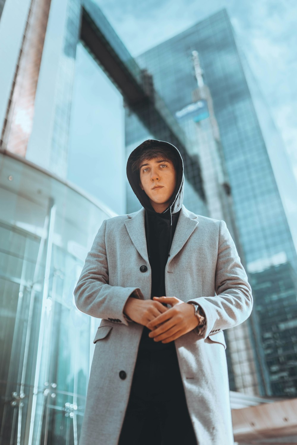 man in overcoat standing outside building