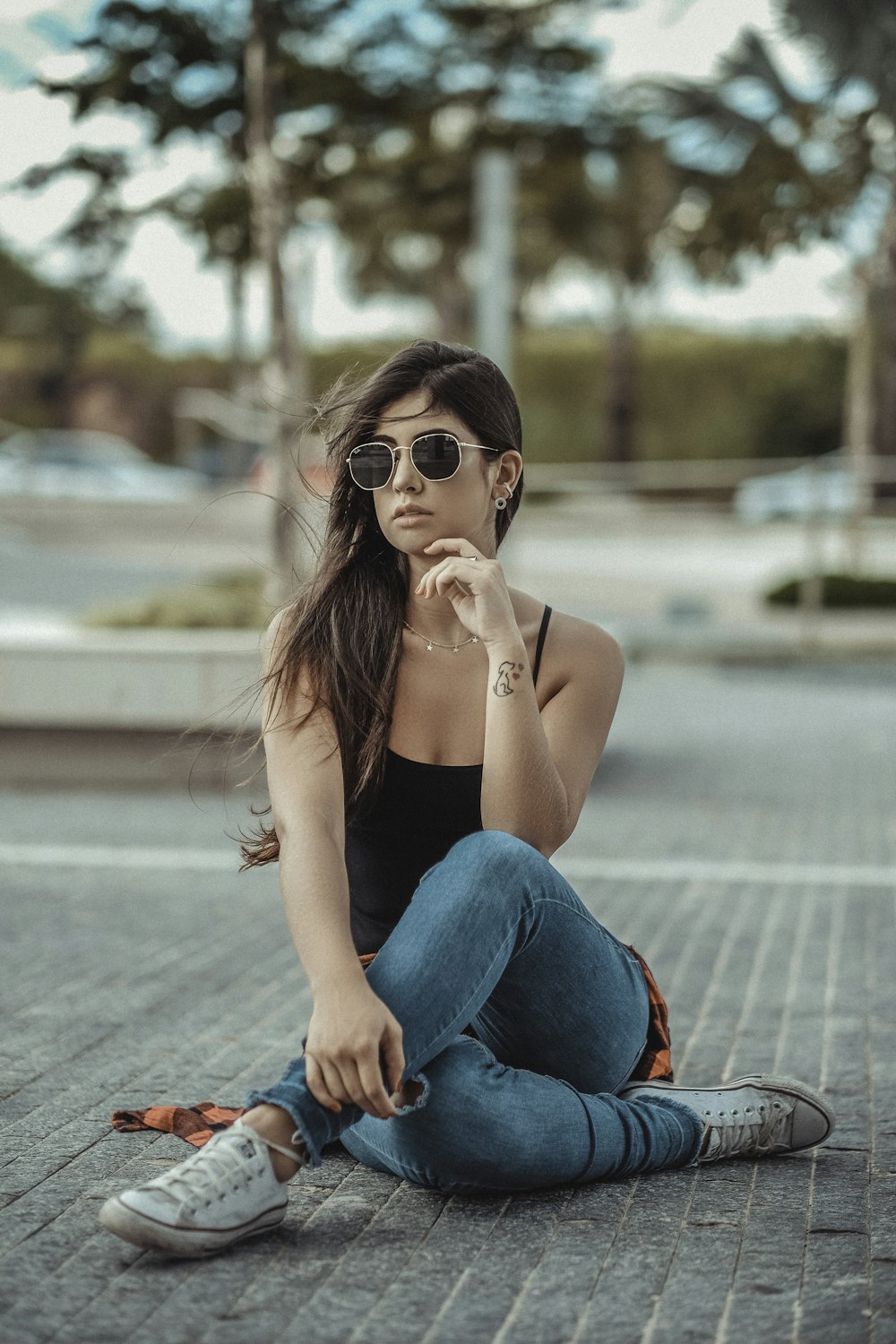 woman wearing shades, black top and blue jeans