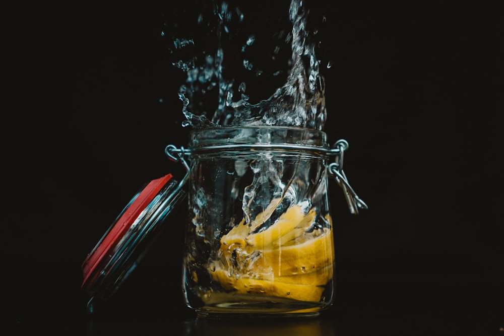 sliced lemon in clear glass jar with water