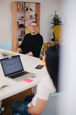 smiling man beside writing person