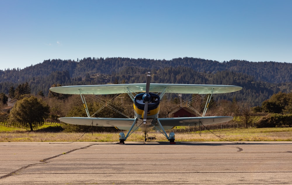 green propeller plane on brown pathway during daytime