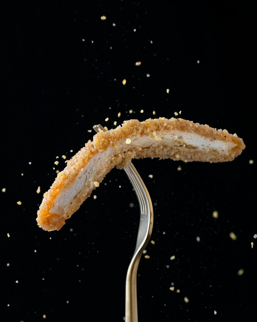 stainless steel fork with sliced breaded meat