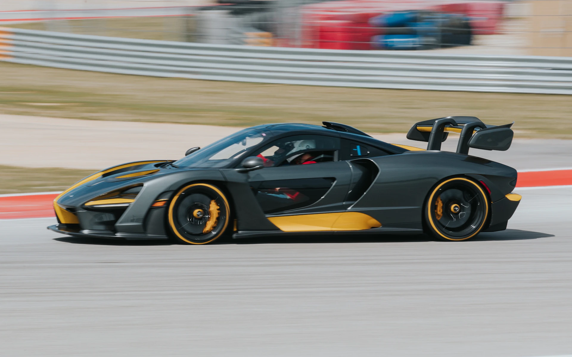 High-resolution photo of a sleek sports car speeding on a racetrack during golden hour.