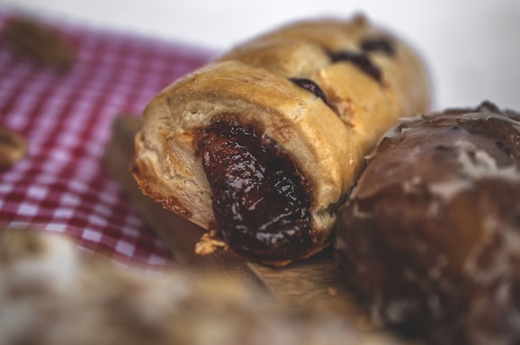Close-up of a crispy pastel filled with seasoned ground meat on a rustic wooden table.