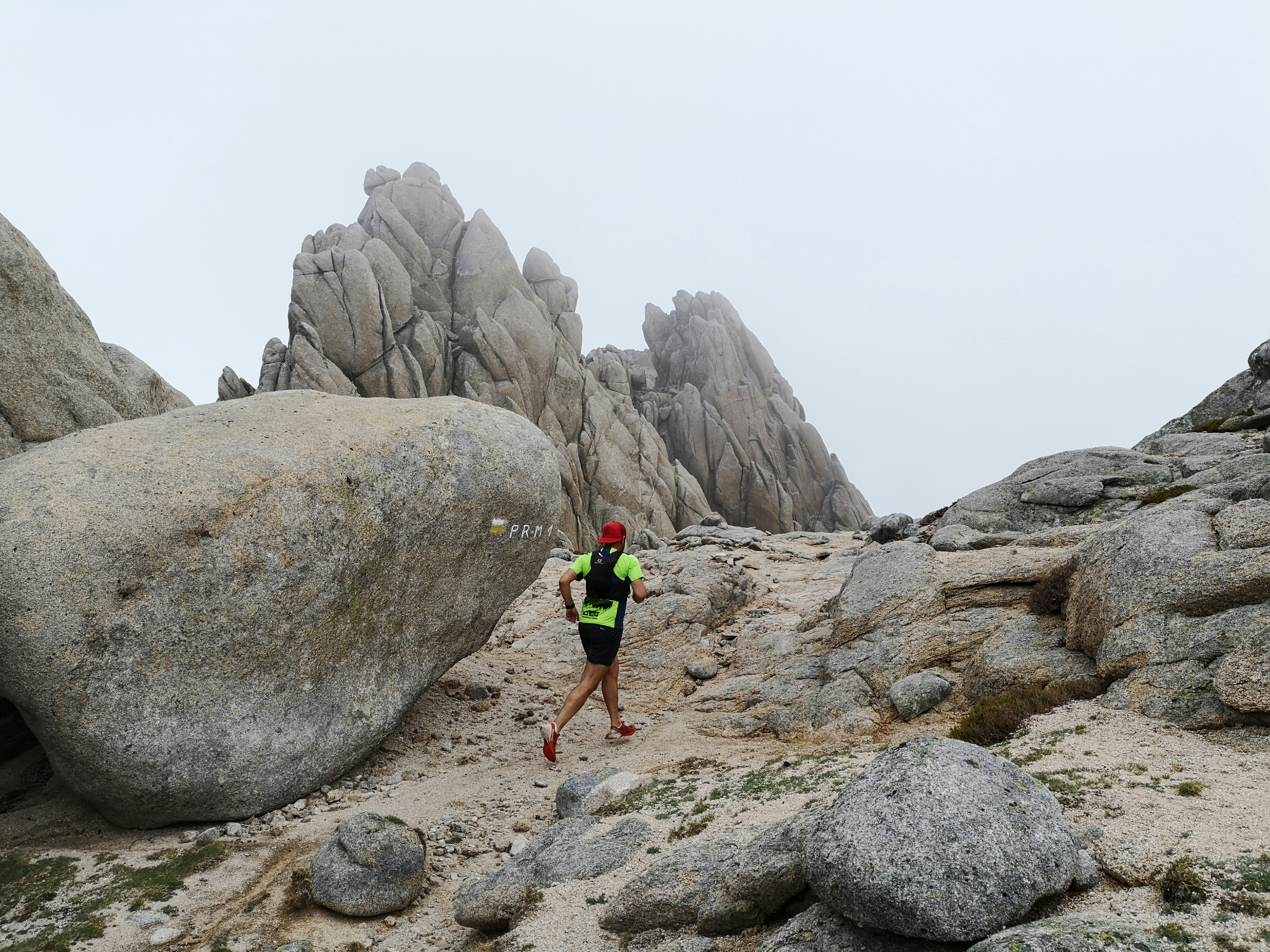 Trail running at Las Torres de la Pedriza on a foggy morning. La Pedriza is a geological feature on the southern slopes of the Guadarrama mountain range of great scenic and leisure interest. Access is from Manzanares el Real, a municipality in the northwest of the Community of Madrid (Spain).