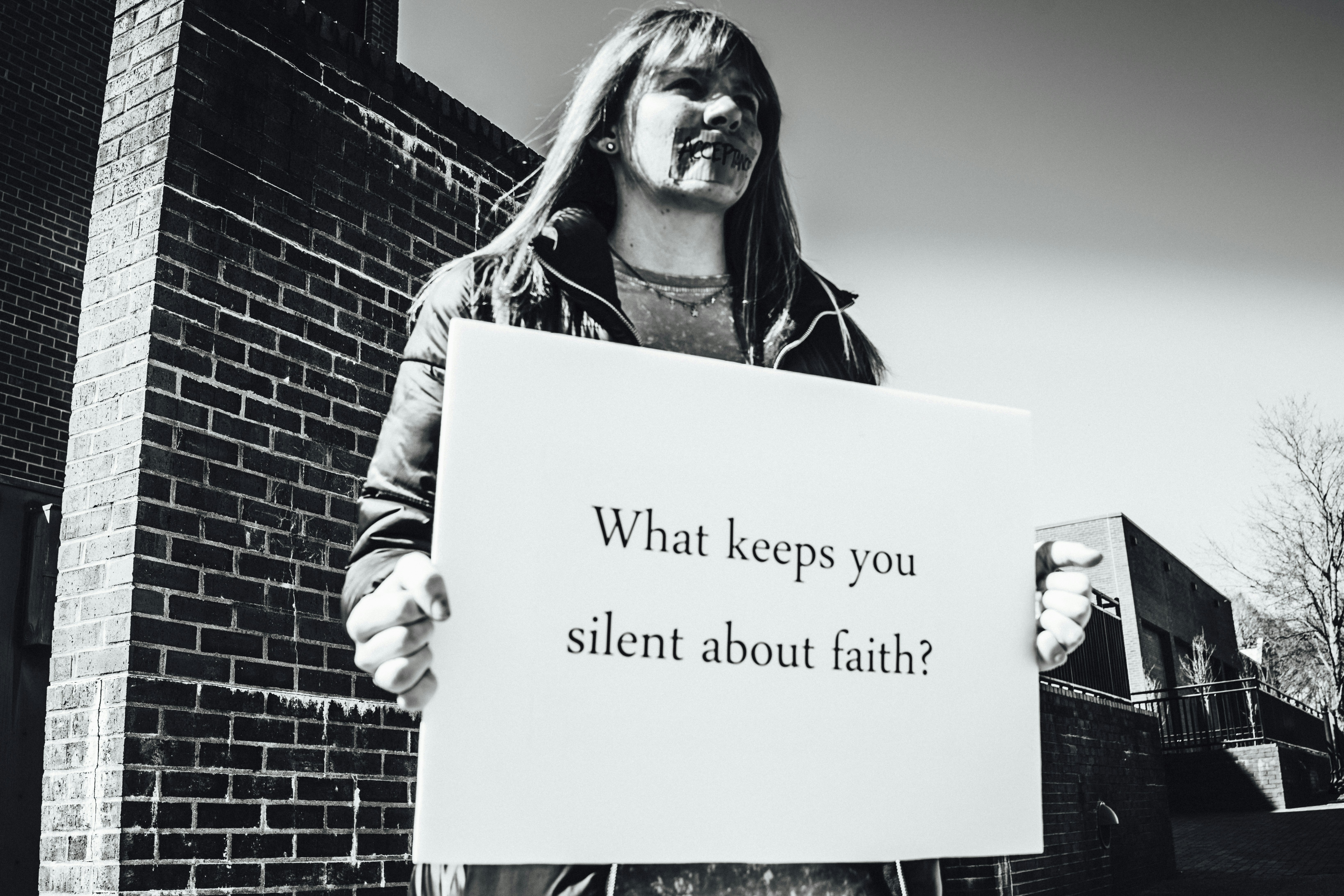 I found this woman on the corner of the school campus holding up this message with tape over her mouth written on it the word “ACCEPTANCE” this being her answer to the question she posed “WHAT KEEPS YOU SILENT ABOUT FAITH?” and so I say what is it our answer for us