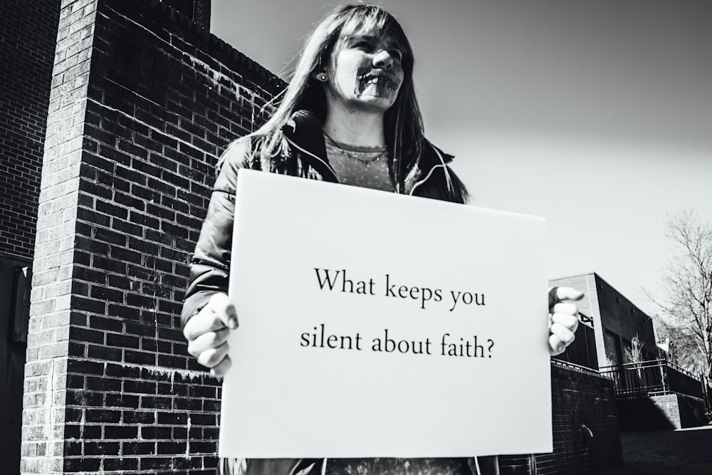 grayscale photography of woman holding board