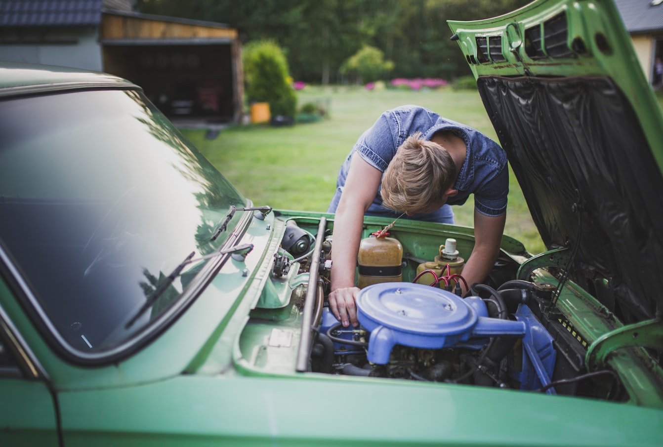 man looking at a car's engine