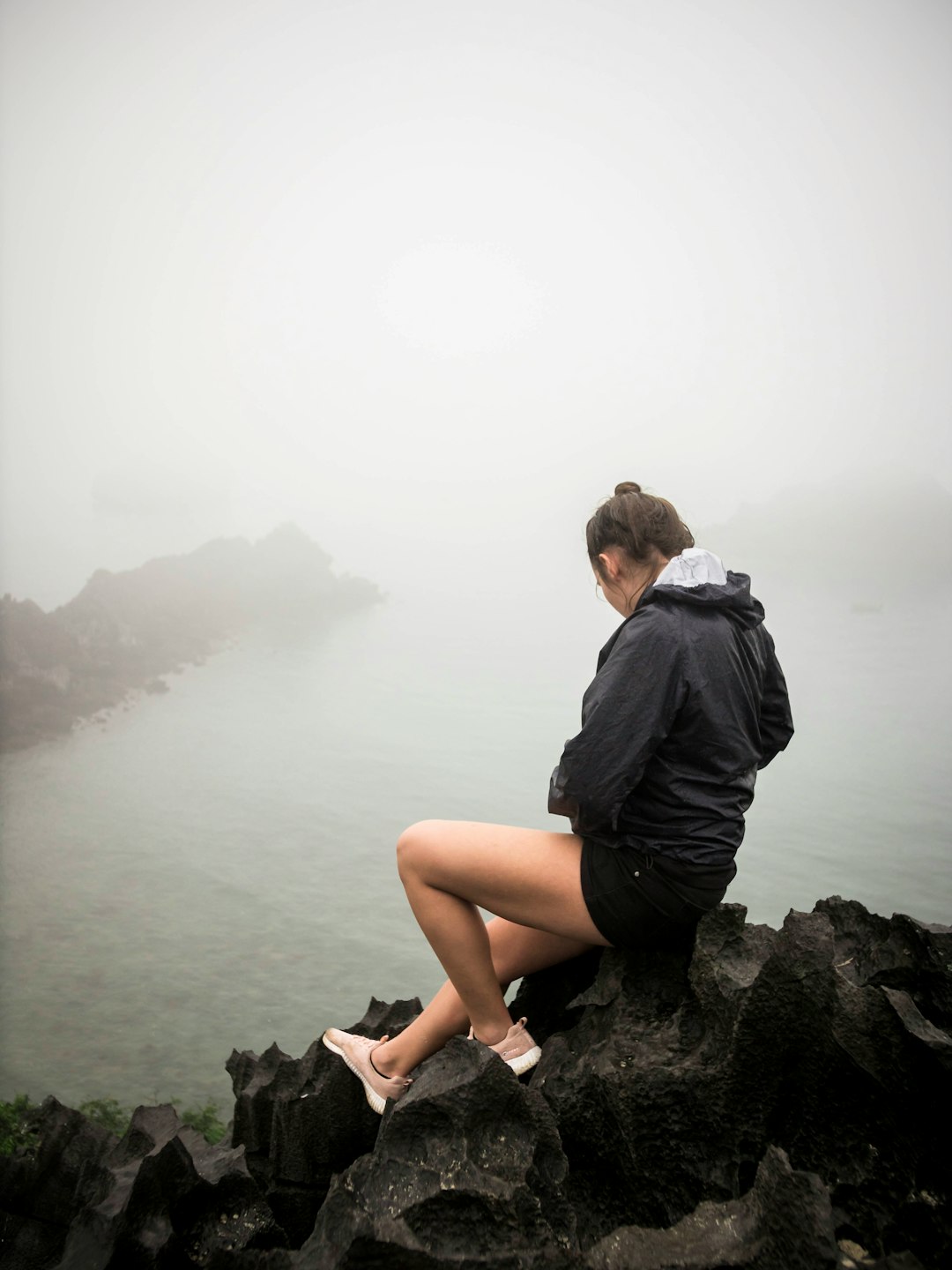 woman sitting down on rock