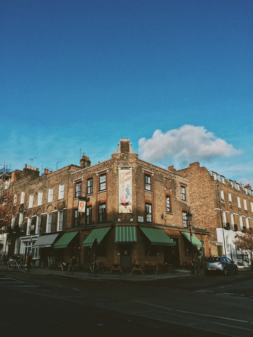 shallow focus photography of brown painted building under white and blue sky at daytime