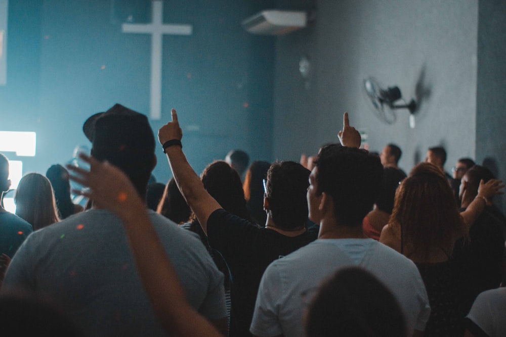 people standing near white cross