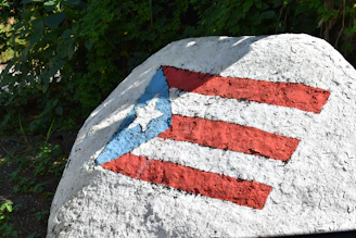 A happy customer proudly wearing a handcrafted Puerto Rican flag heart design tee.