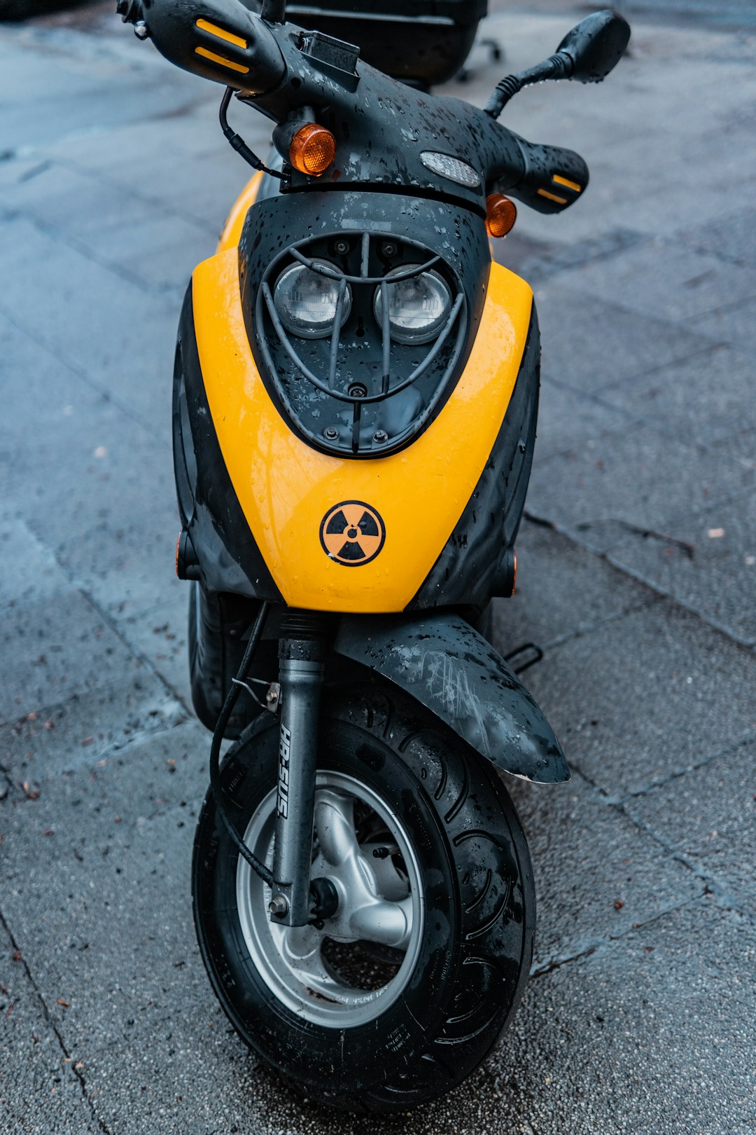yellow and black motor scooter parked on concrete pavement