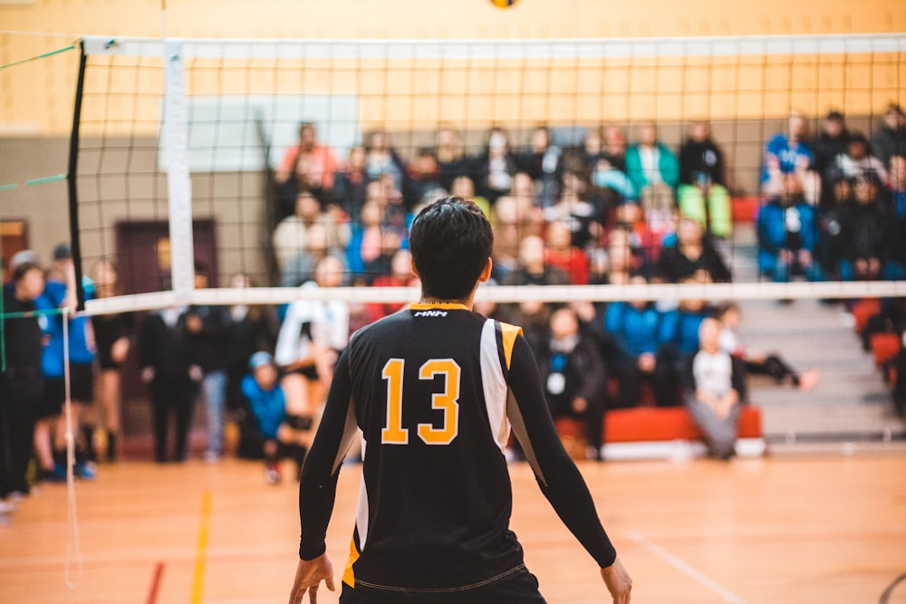 homme portant un maillot de volley-ball noir 13