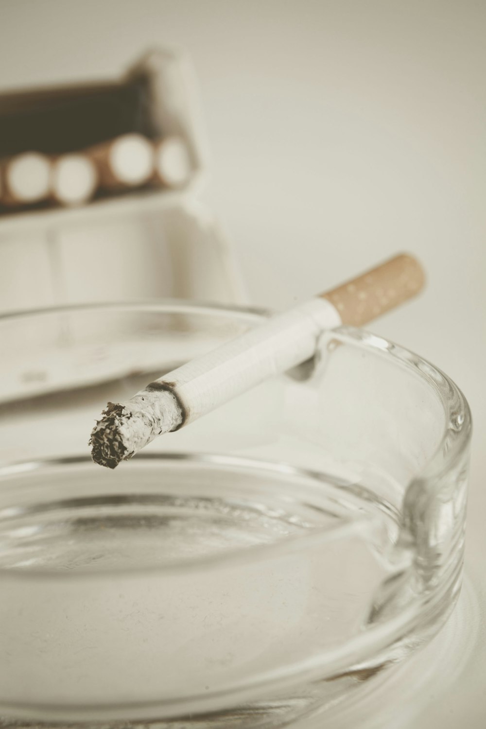 angezündeter Zigarettenstift auf Glasaschenbecher