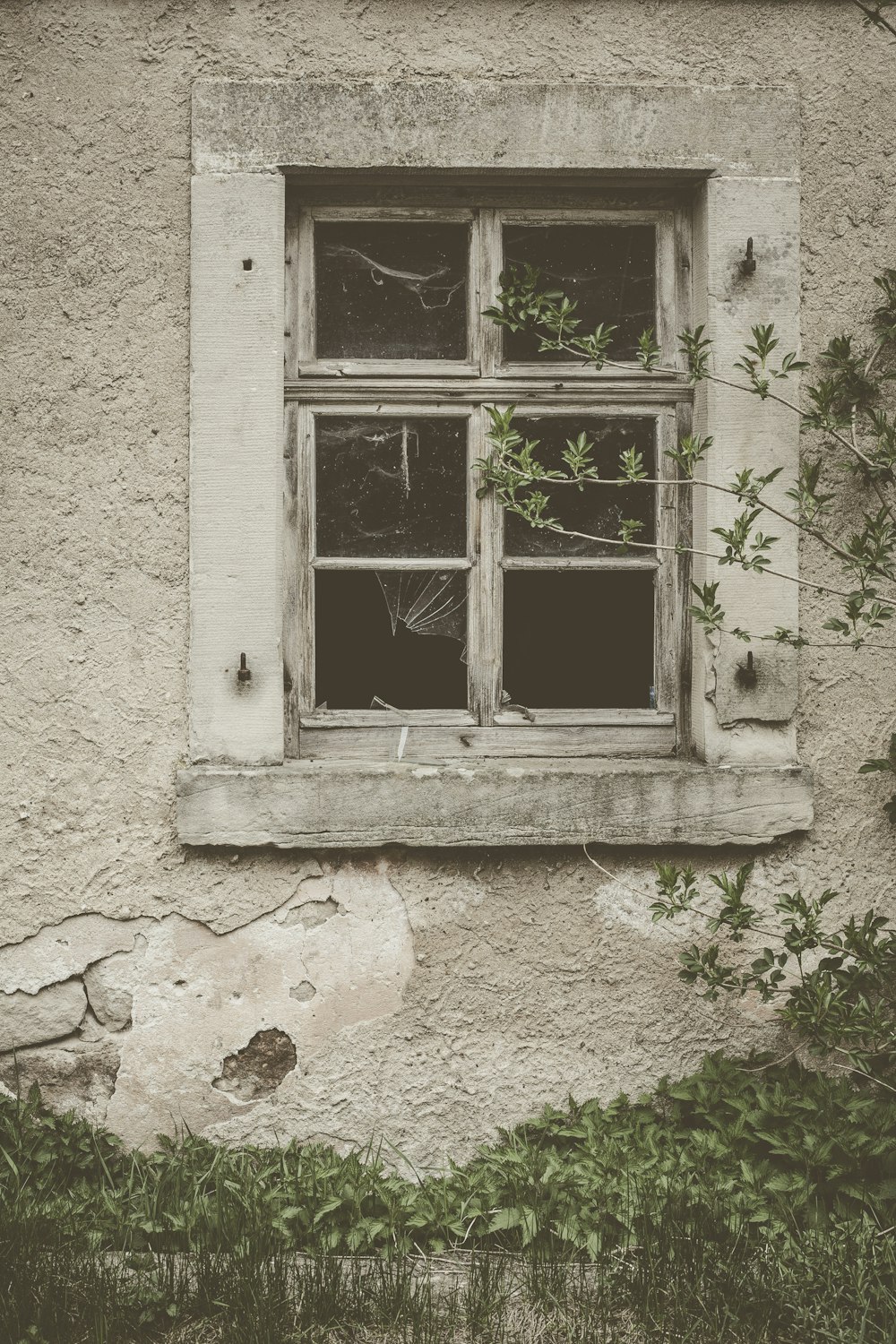 brown window with broken glass on wall