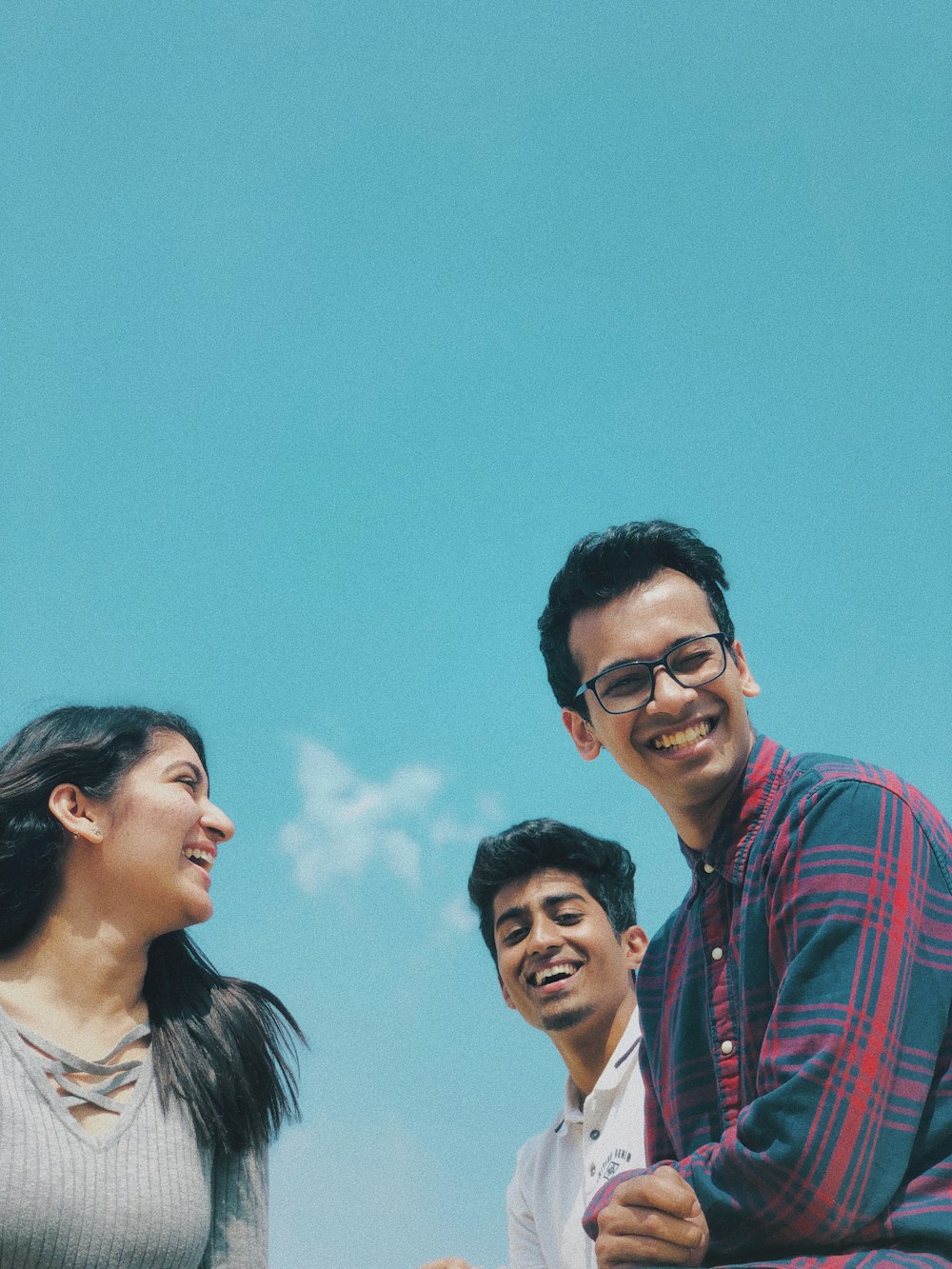 two man facing one woman under white and blue sky at daytime