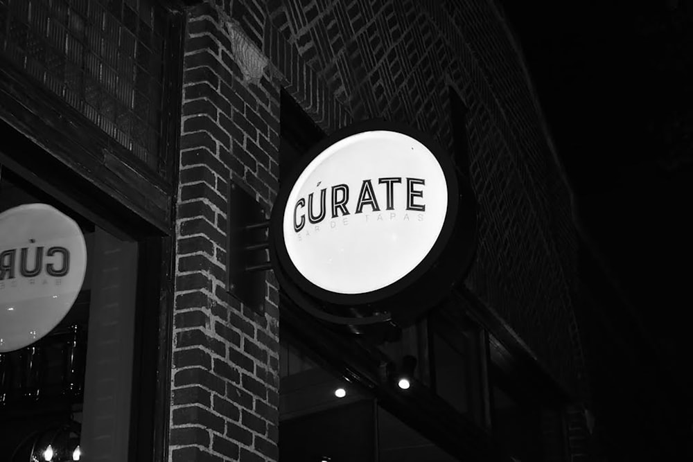 grayscale photography of Curate signage