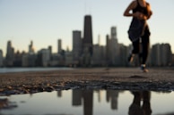 An early morning jogger in Lumina gear crossing a city bridge, the soft light catching the reflective details.